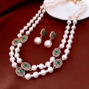 Vintage double layer pearl necklace and emerald style earrings set on red silk