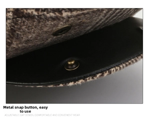 Detail of herringbone wool fabric with bronze metal snap button and leather brim on flat cap