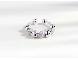 Macro shot of silver anxiety ring with rotating beads in alternating smooth and matte finish