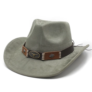 Detail of western cowboy hat featuring golden bull head emblem and studded leather band
