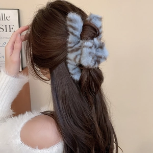 Faux fur hair claw clip in tiger print blue-grey and brown shown on model's hair