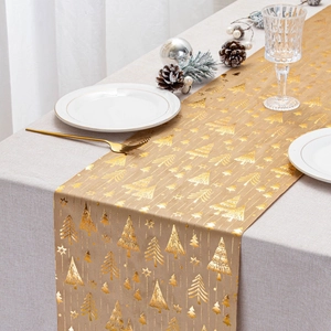 Detail of beige velvet table runner featuring golden Christmas trees and star patterns