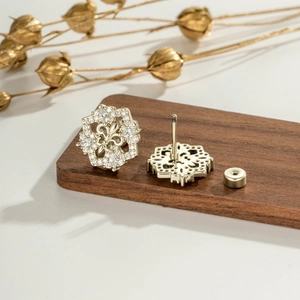 Elegant gold zircon floral earring set with vintage cross design on a wooden display