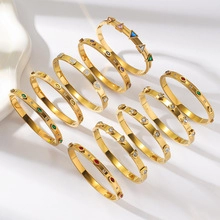 Macro detail of gold plated bangles featuring colorful round and geometric zircon stones