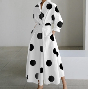 Dettaglio di un abito bianco a maniche lunghe con pois neri e scollatura a V