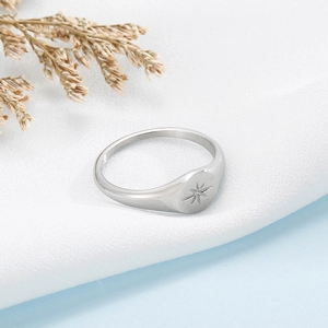 Vue macro d'une bague chevalière polie avec une étoile polaire gravée sur tissu