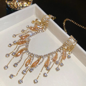 Close-up of luxury gold tassel necklace with champagne teardrop crystals in jewelry box