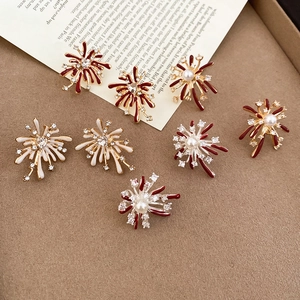 Close-up of red and white enamel firework earrings with pearls and crystals