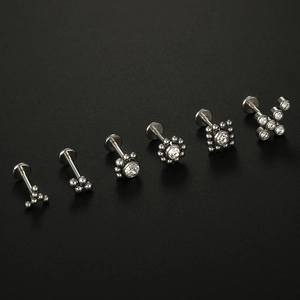 Macro shot of six 316L stainless steel labret studs with white zircon inlay on black