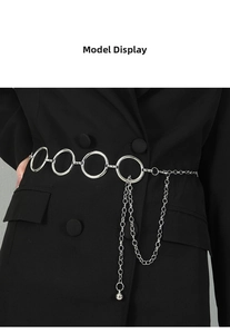 Close-up of silver metal waist chain with interlocking rings and fringe tassel details