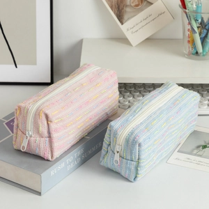 Detail of pink and blue tweed pencil cases in a stylish desk organization setting