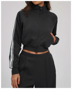 Detail view of the high-collar zip-up jacket with white athletic stripes on the sleeves