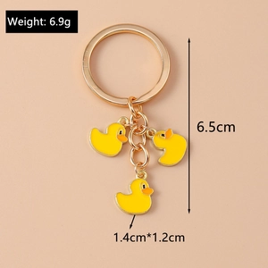 Golden metal keychain with three yellow duck charms and precise size measurements