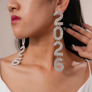 Detailed close-up of long silver 2026 number earrings with crystals on female model