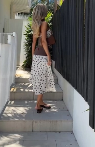 Detail of a white polka dot midi skirt with lightweight flowing chiffon fabric