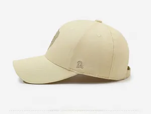 Detail view of beige cotton baseball cap featuring side 3D letter D embroidery