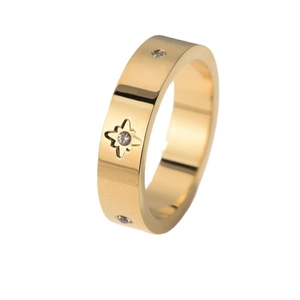 Polished gold star-patterned ring with center gem and pavé side stones on white background