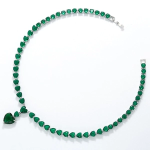Macro view of emerald green heart-shaped cubic zirconia necklace with silver setting