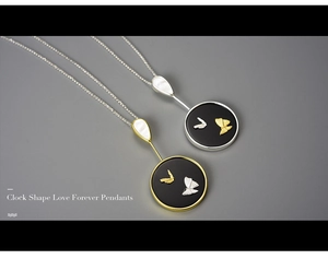 Detailed macro view of an elegant gold and silver butterfly relief pendant on a black base