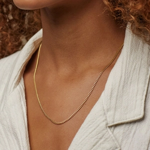 Close-up of a minimalist 14k gold plated cuban link chain necklace on model neck