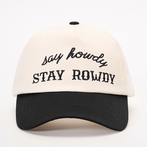 Detailed close-up of STAY ROWDY embroidery on a two-tone black and white baseball cap