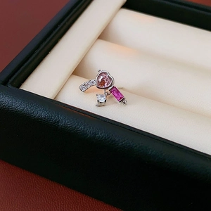 Macro shot of silver heart earrings with pink gemstones in a leather jewelry box