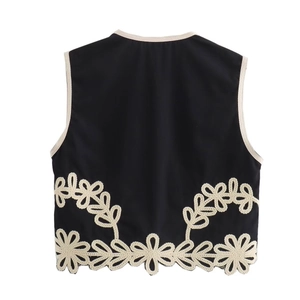 Détail du gilet noir sans manches avec broderie florale blanche et ourlet au crochet