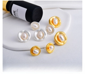 Detail view of Baroque freshwater pearl earrings in gold and silver matte finishes