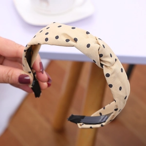 Dettaglio del cerchietto beige a pois con nodo e fodera interna nera antiscivolo