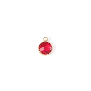 Macro shot of 7mm round red birthstone pendant with faceted glass in gold setting