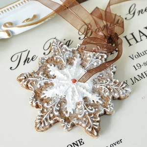 Rustic resin snowflake ornament with white gingerbread texture and red star detail