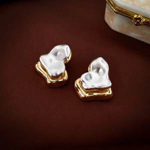 Close-up of vintage heart stud earrings with mixed gold and silver metallic finish