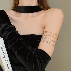 Detail of minimalist metallic armbands in gold and silver with multi-layered wire design