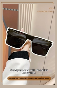 Close-up of black and white oversized sunglasses with silver rivet detail and wide frames