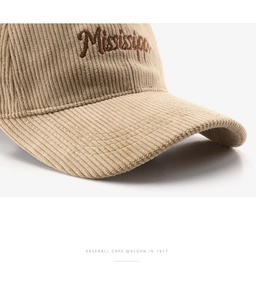 Close-up of khaki corduroy texture with brown Mississippi embroidery on a baseball cap