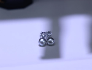 Detail of freshwater pearl earrings with round grey pearls and cubic zirconia stones