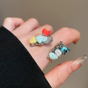 Close-up of irregular shell flower ring with multi-colored crystals on silver base