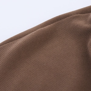 Macro shot of dark brown high-density knit fabric texture and durable edge stitching