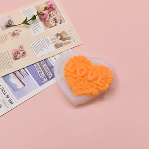Macro view of heart-shaped silicone mold with LOVE letter and rose flower textures