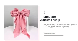 Macro shot of smooth pink satin ribbon bow hair clip with elegant long streamers