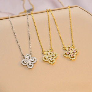 Macro detail of three clover pendants with drop-shaped zircon crystals on elegant O-chains