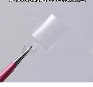 Macro shot of ultra-thin transparent square fake nail held by pink professional tool