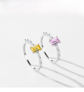 Detail of S925 silver rings with emerald-cut yellow and pink cubic zirconia stones