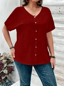 Detailed view of the V-neckline and button-down front on a deep red short sleeve blouse