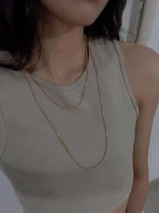 Close-up of elegant gold multi-layered snake chain necklace worn by a model