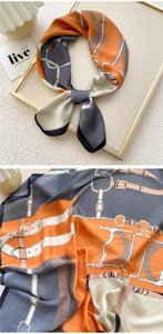 Detail of silk scarf showing equestrian chain and belt pattern on satin fabric