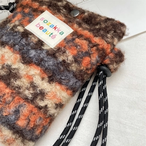 Gros plan du sac floral en peluche montrant la texture douce de la laine et le cordon