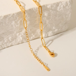 Detailed close-up of golden stainless steel paperclip chain with S.STEEL engraved tag
