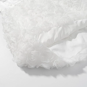 Detailed macro view of white 3D rose floral lace fabric with soft mesh texture