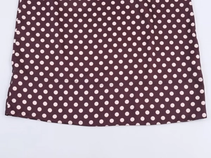 Detail von Vintage-Polka-Dot-Rockstoff mit feiner Naht am lila Saum des Rocks